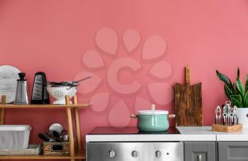 Set of utensils near color wall in kitchen�