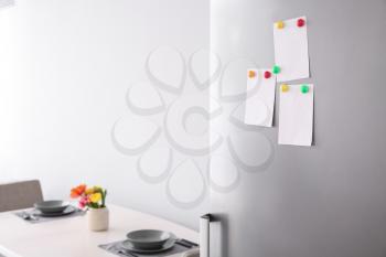 Papers with magnets on fridge door�