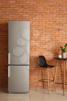Modern fridge, table and chair in kitchen�