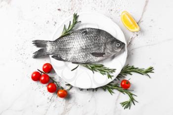 Plate with fresh fish on table�