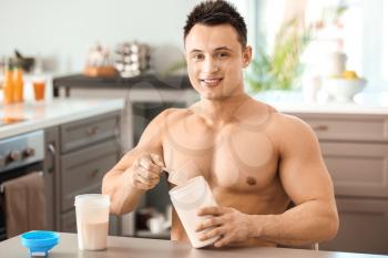 Sporty man making protein shake at home�