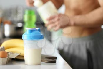Protein shake and ingredients on table in kitchen�