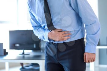 Young man suffering from stomachache in office�
