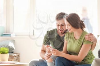 Happy couple with pregnancy test at home�