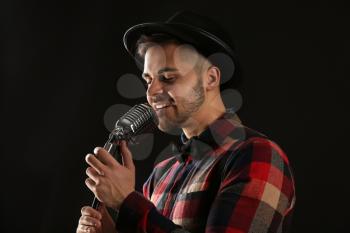 Handsome male singer with microphone on stage�