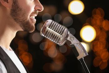 Handsome male singer with microphone on stage�