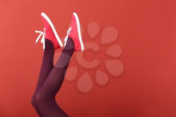 Young woman in stylish shoes on color background�