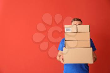 Delivery man with boxes on color background�