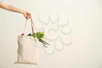 Female hand with eco bag on white background. Zero waste concept�