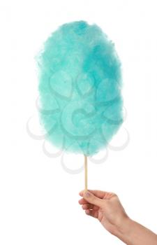 Female hand with tasty cotton candy on white background�