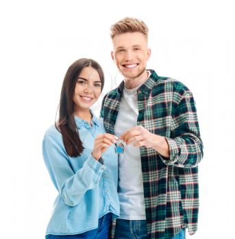 Young couple with key from their new house on white background�