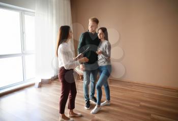 Real estate agent showing young couple a new house�