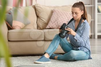 Teenage girl with photo camera at home�
