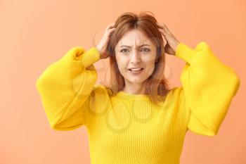 Portrait of stressed mature woman on color background�