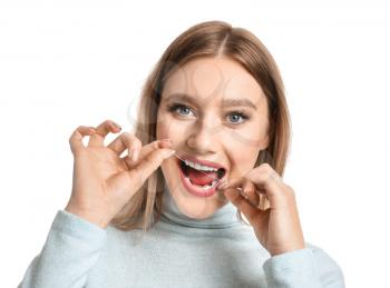 Woman flossing teeth on white background�