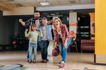 Family playing bowling in club�