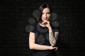 Beautiful tattooed woman on dark background�