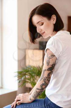 Beautiful tattooed woman at home�