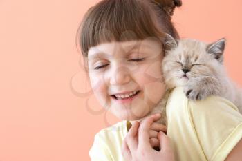 Girl with cute fluffy kitten on color background�