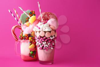 Different delicious freak shakes on color background�