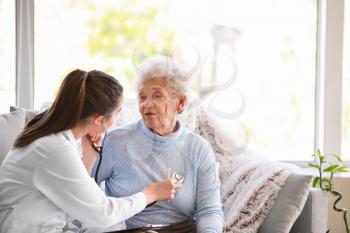 Doctor examining senior woman in nursing home�