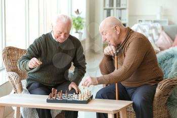 Senior men playing chess in nursing home�