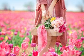 Beautiful young woman in tulip field on spring day�