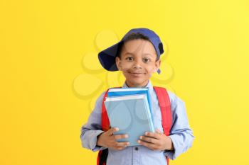Cute African-American schoolboy on color background�