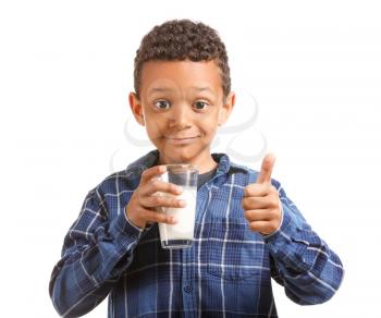 Cute African-American boy with glass of milk showing thumb-up on white background�
