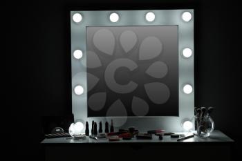 Table with cosmetics and mirror in modern makeup room�
