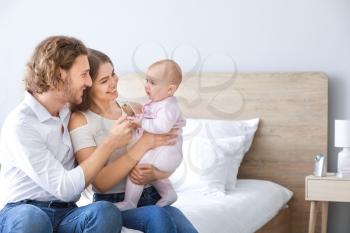Happy parents with cute little baby at home�