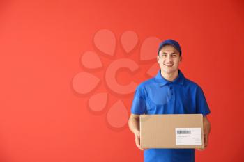 Delivery man with box on color background�