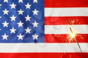 Sparkler against USA flag. Independence Day celebration�