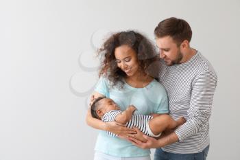 Portrait of happy interracial family on light background�
