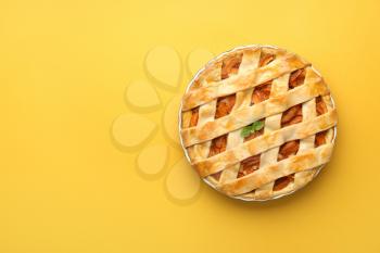 Tasty peach pie on color background�