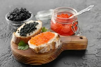 Sandwiches with delicious caviar on dark background�