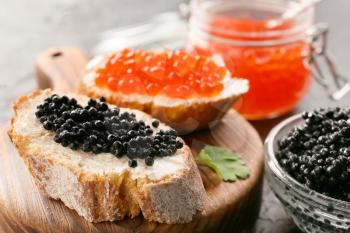 Sandwiches with delicious caviar on board, closeup�