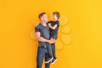 Portrait of father and son on color background�