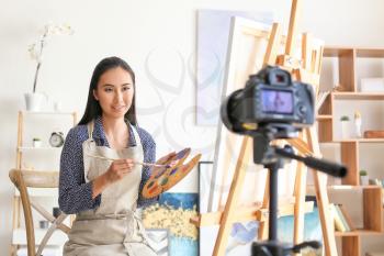 Female Asian blogger recording video in workshop�
