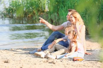 Happy family on summer picnic near river�