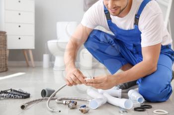 Plumber with tools working in restroom�