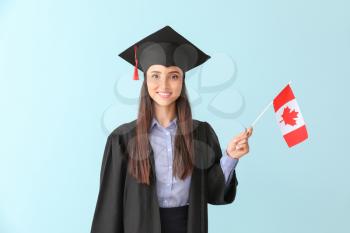 Female graduate with Canadian flag on color background�
