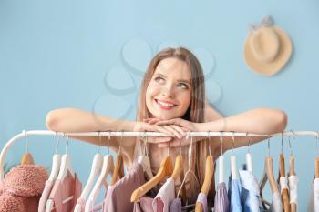 Young woman standing near clothes rack in dressing room�