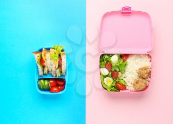 School lunch boxes with tasty food on color background�