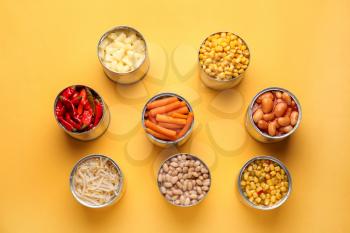 Tin cans with different food on color background�