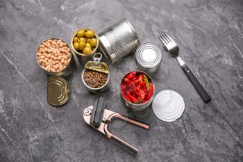 Tin cans with different food on grunge background�