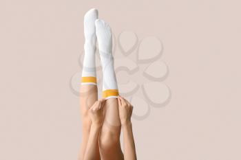 Legs of young woman in socks on light background�