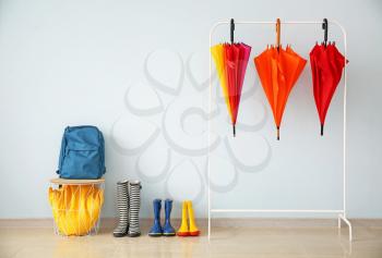 Stylish umbrellas with gumboots in hall�
