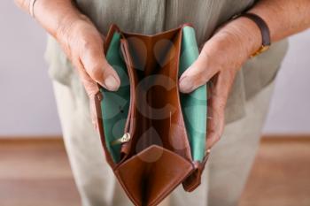 Elderly woman with empty wallet, closeup. Concept of poverty in retirement�