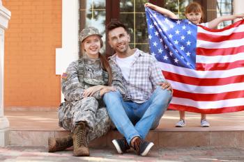 Happy female soldier with her family outdoors�